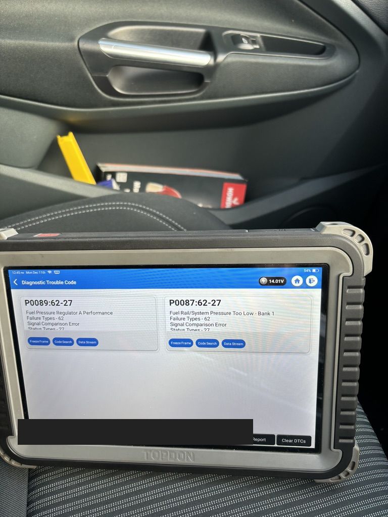 TOPDON diagnostic tablet showing P0087 fuel rail pressure too low and P0089 fuel pressure regulator performance codes on a Ford C-MAX