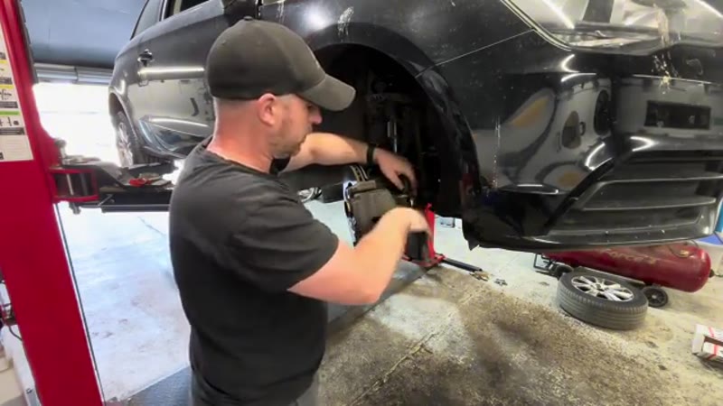 Removing the caliper guide pin bolts with a 7mm Allen key on the Audi