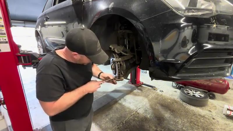 Cleaning rust from the Audi caliper bracket where the pads sit