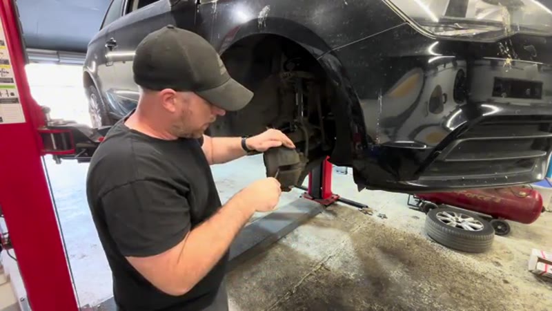 Levering the caliper piston back with a screwdriver on the Audi