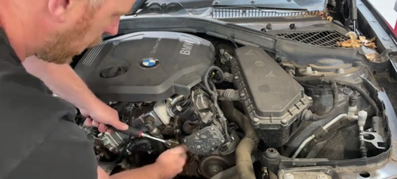 Releasing the auxiliary belt tension with a 16mm socket on the BMW 116d tensioner