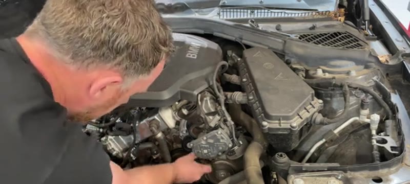 Routing the new auxiliary belt around the pulleys on the BMW 1 Series 116d