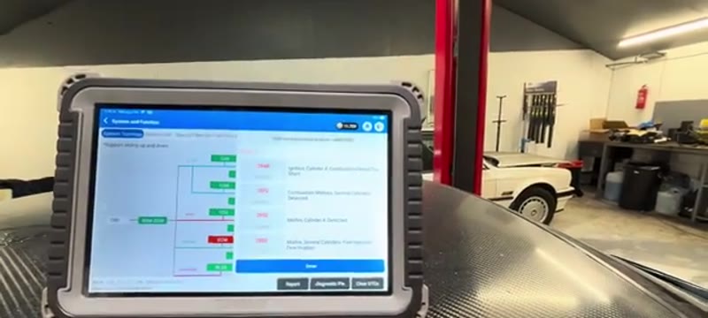 OBD diagnostic tablet showing a cylinder 4 misfire fault code on the BMW 335i