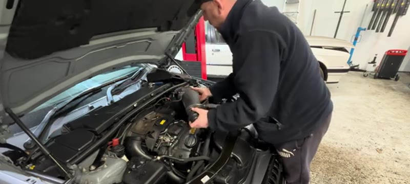Removing the air intake pipe from the BMW 335i engine bay