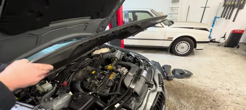 Lifting the scuttle panel away to reach the rear of the BMW 335i engine