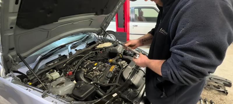 Fitting the new spark plugs into the BMW 335i with a socket and extension