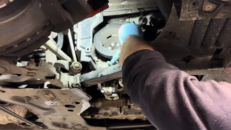 Releasing the auxiliary belt tensioner through the wheel arch on the Citroen C4