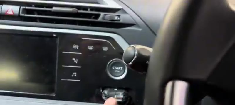 Inserting the key into its slot beside the start button on the Citroen C4
