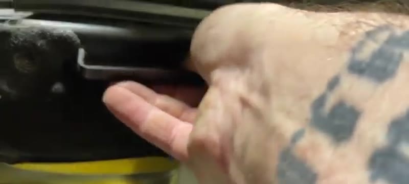 Hand clipping the pollen filter housing cover shut on a Citroën DS3 before refitting the plastic cover