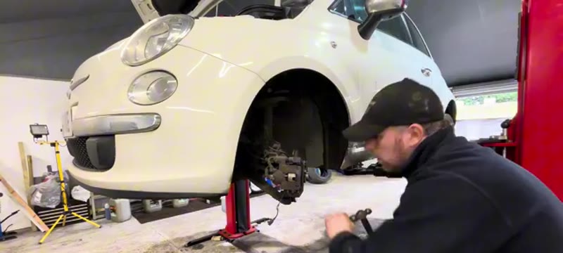 Knocking the main caliper pin out of the Fiat 500 brake caliper with a punch