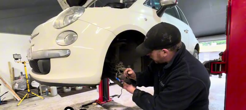 Pushing the brake caliper piston back on a Fiat 500 so the caliper can release from the pads