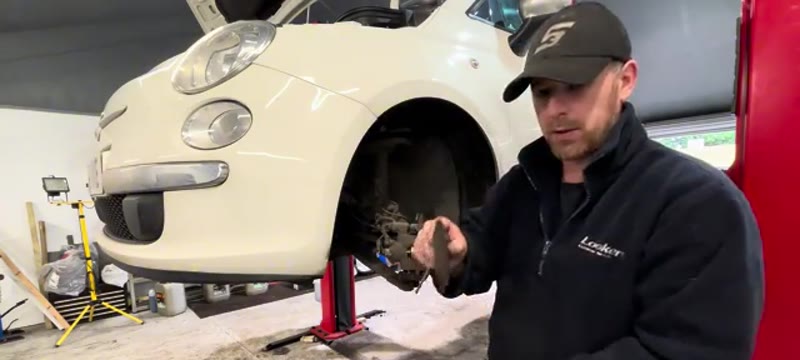Inspecting a worn brake pad removed from the Fiat 500 front caliper