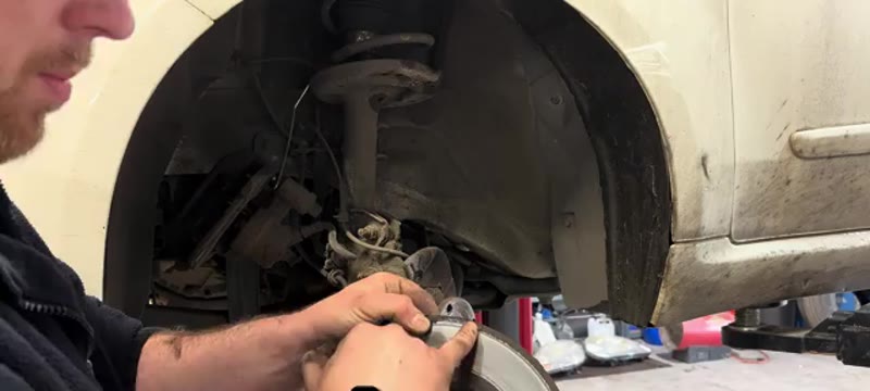 Old corroded brake disc being removed from the Fiat 500 front hub