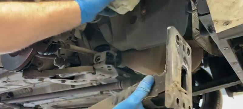 Sliding the underbody brace bar clear after moving the Fiat 500 washer bottle aside