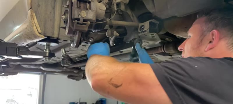 Fitting the new lower wishbone into position under the Fiat 500