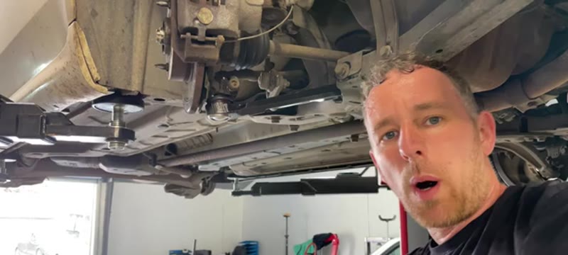 Refitting the underbody brace bar beneath the Fiat 500 during reassembly