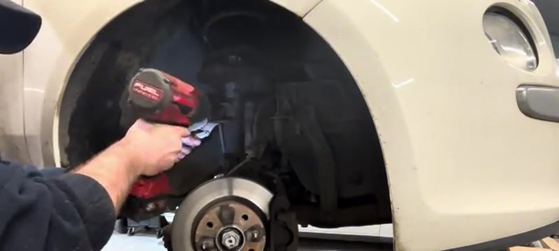 Undoing the anti-roll bar drop link inside the Fiat 500 front wheel arch