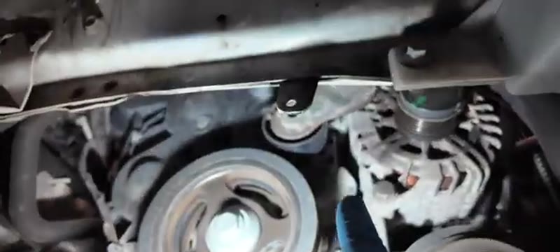Auxiliary belt and tensioner visible through the wheel arch of the Ford Focus 1.6 TDCi