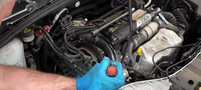 Prying the old water pump away from the engine block on the Ford Focus 1.6 TDCi