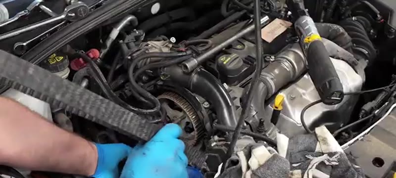 Feeding the new cam belt around the pulleys on the Ford Focus 1.6 TDCi