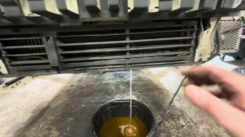 Coolant draining from the Ford Puma radiator drain tap into a pan