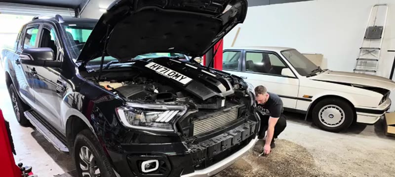 Removing the four 10mm bolts from underneath the Ford Ranger front bumper
