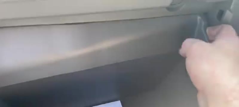 Unclipping the side of the Transit glove box so it hinges down