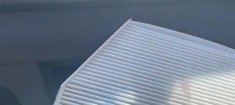 Old pollen filter removed from a Ford Transit 2021 showing the pleats and airflow direction edge
