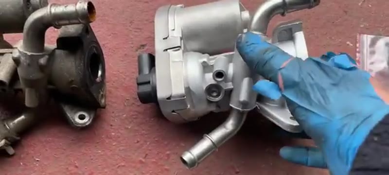 Old and new EGR valves side by side on the bench while the coolant pipe is transferred