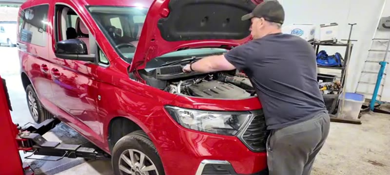 Removing the Torx screws along the scuttle panel at the top of the Ford Transit Connect bumper