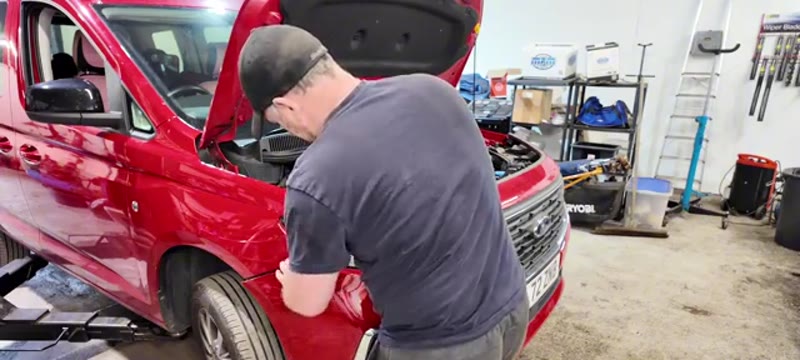Pulling the front bumper free from its clips on the Transit Connect