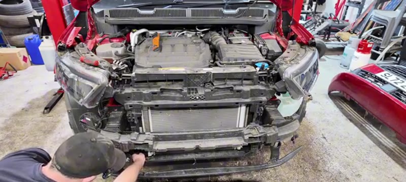 Undoing the air conditioning pipe connections on the condenser with a Torx bit