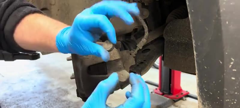 Popping the plastic sliding pin covers off the Ford Transit Connect brake caliper