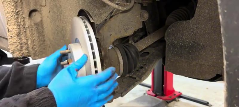 Offering the shiny new brake disc onto the cleaned hub