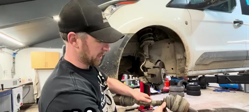 Inspecting the worn outer CV joint on the old Transit Connect driveshaft