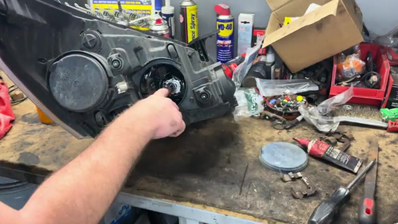 Removing the rubber dust cover and old H7 bulb from the back of the Transit Custom headlight on the bench