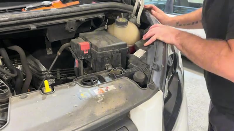 Refitting the headlight unit into position at the front of the Transit Custom