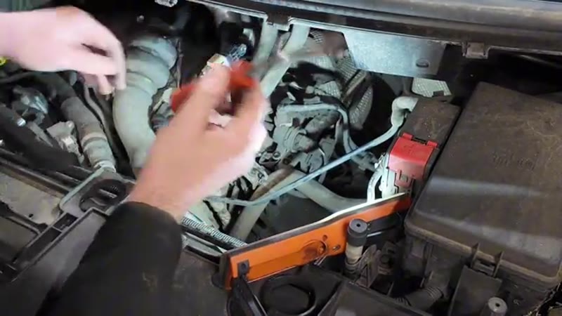 Using a trim tool to release the pipes and bracket in front of the Transit Custom vacuum pump