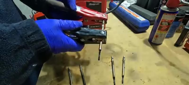 Testing each glow plug in turn with the removed plugs lined up on the bench
