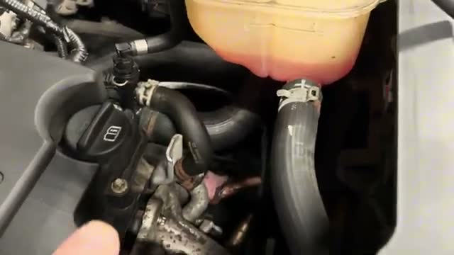 Orange coolant staining showing the leak area below the header tank