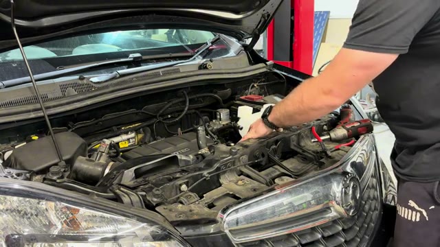 Fitting the new coolant header tank into place on the Vauxhall Mokka