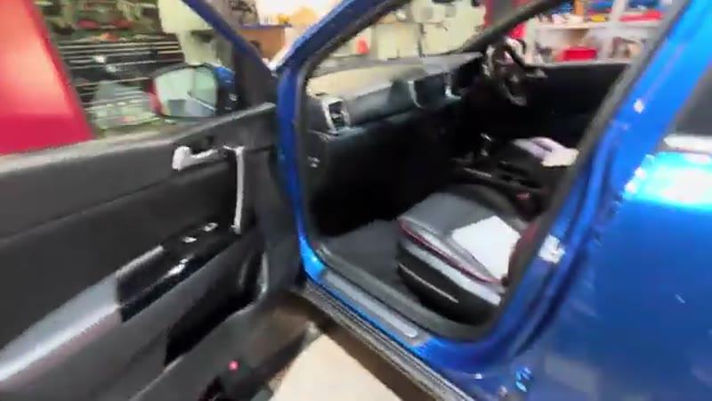 Passenger door open on a blue Kia Sportage 2020, ready to access the glove box