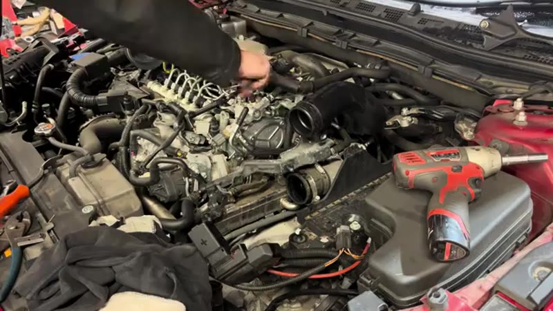 Refitting the hoses, bracket and battery in the Mazda 3 engine bay