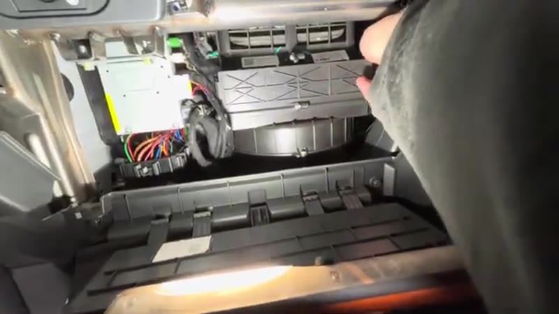 Releasing the pollen filter housing cover behind the glove box on the MG ZS