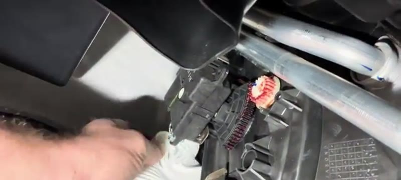 Squeezing the new pollen filter into its housing in the Nissan Qashqai footwell
