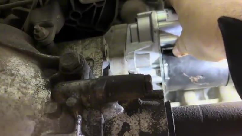 Lifting the new starter motor up into position on the gearbox dowel