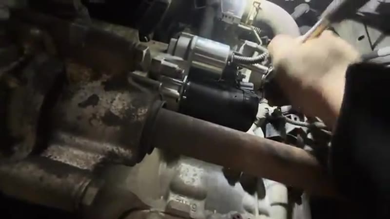 Tightening the terminal nuts on the new starter motor with a socket and ratchet