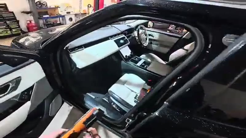 Passenger door open on a Range Rover Velar showing the dashboard and glove box area