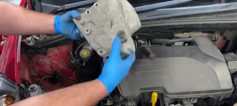 Lifting the support bracket away to expose the cam belt covers on a Renault Clio