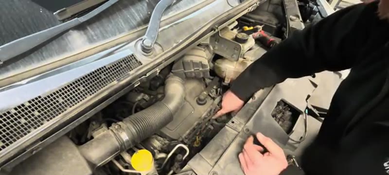 Pointing out the location of the four glow plugs in the Renault Trafic 1.6 dCi engine bay